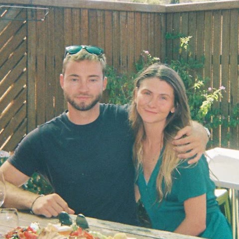 Ross and Georgia at an outdoor table with wine and a share platter